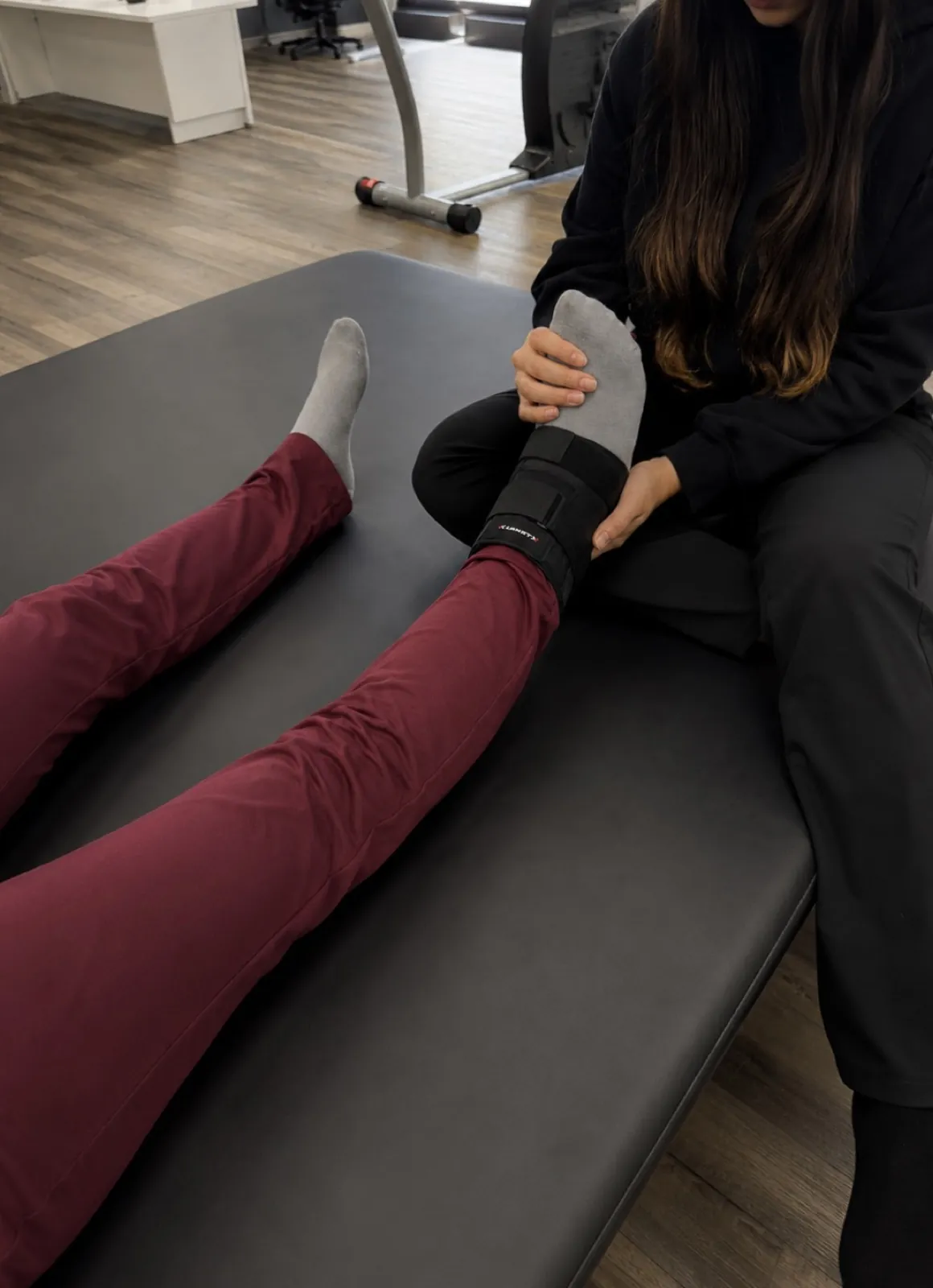 A therapist working hands-on on a patient's ankle at our clinic